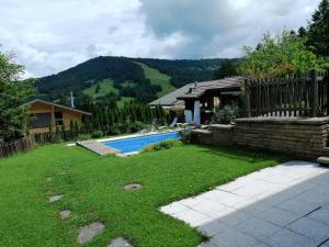 a yard with a swimming pool and a house at Le Paradis du Chalet Perce-Neige in Châtel-Saint-Denis