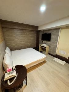 a bedroom with a bed and a phone on a table at 貴族旅社 宜蘭縣旅館095號 in Luodong
