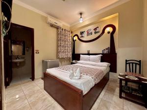 a bedroom with a large bed and a sink at Hotel G in Sūhāj +25 photos