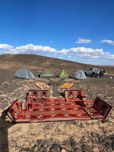 a group of tents in the middle of a field at Desert mountains camping in Merzouga +117 photos