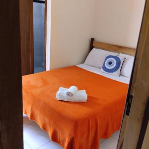 a bedroom with a bed with two towels on it at Pousada Mandala in Palmeiras