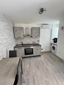 a kitchen with a table and a stove top oven at "DOMUS LEONE" - Nel Borgo di Capri Leone in Capri Leone