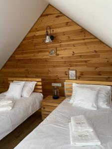 two beds in a room with a wooden ceiling at Wilcza Chata in Polańczyk