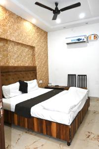 a bedroom with a bed with white and black sheets at Hotel Embassy In - 200 Mtrs - Near Golden Temple in Amritsar +11 photos