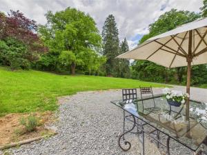 a table with an umbrella next to a field at Chateau Mas Levrault in Saint-Priest-Taurion
