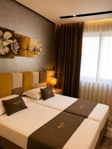 a hotel room with two beds and a window at Nova Apartaments Qerret ZL in Golem