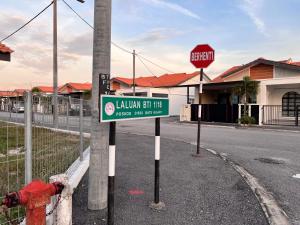 a street sign next to a fire hydrant on a street at Dgajah Homestay in Batu Gajah