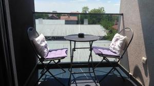 a balcony with two chairs and a table on a balcony at Cozy Studio-Self check in in Beograd
