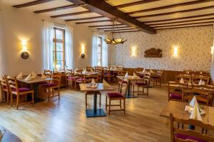 a restaurant with tables and chairs in a room at Hotel Restaurant St. Germanshof in Bobenthal