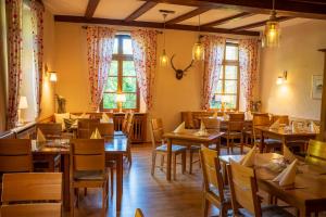 a restaurant with wooden tables and chairs and windows at Hotel Restaurant St. Germanshof in Bobenthal +27 photos