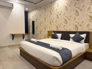 a bedroom with a large bed with blue and white pillows at Sunburry Hotel Khatu 700mts from Temple in Khātu