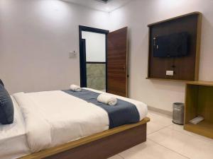 a bedroom with a bed and a flat screen tv at Sunburry Hotel Khatu 700mts from Temple in Khātu