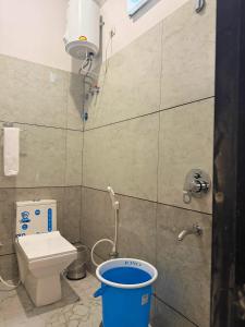 a small bathroom with a toilet and a bucket at Sunburry Hotel Khatu 700mts from Temple in Khātu