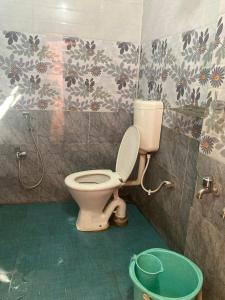 a bathroom with a toilet and a bucket at Blue Horizon hotel & restaurent in Nalbāri
