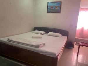 a bed with two pillows on it in a room at Blue Horizon hotel & restaurent in Nalbāri