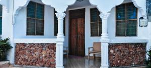 a house with white columns and a door at primavera jambiani in Mfumbwi