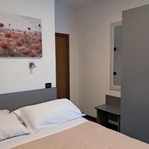 a bedroom with a bed and a painting on the wall at Albergo Covili in Pavullo nel Frignano