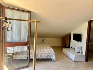 a bedroom with a bed and a tv in it at AgroVerde Apartment a 10 minuti da Alghero in Tottubella