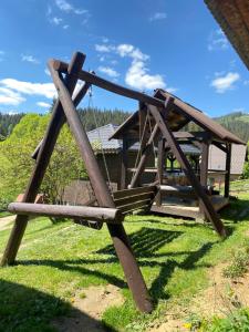 a wooden structure sitting on top of a field at Котедж Славний гуцул & СПА чани джакузі in Yablunytsya