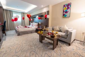 a living room with a couch and a table with balloons at Corniche Hotel Al Khobar in Al Khobar