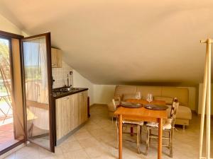 a kitchen and dining room with a table and chairs at AgroVerde Apartment a 10 minuti da Alghero in Tottubella