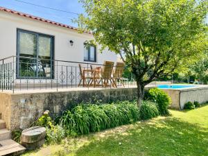 a house with a tree and a swimming pool at Paraiso do Rio Casa T1 in Mondim de Basto