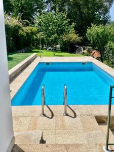 a swimming pool with blue water in a yard at Paraiso do Rio Casa T1 in Mondim de Basto