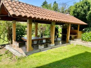 a pavilion with a table in a garden at Paraiso do Rio Casa T1 in Mondim de Basto
