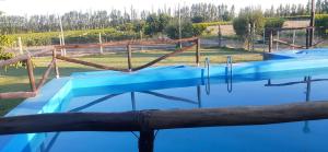 a swimming pool with blue water in a park at FiNCA DACA in Junín