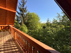 a balcony of a cabin with a view of trees at Casa Sunetul Padurii din Belis Apuseni in Călăţele +31 photos