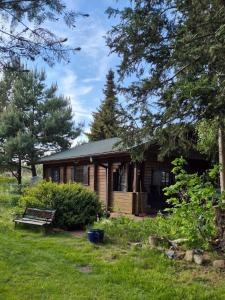 a small wooden house with a bench in a yard at Haus Tausendschön in Torgelow