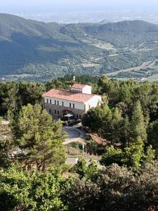 a large building on top of a hill with trees at Albergue Niu d'Estels in Albiol