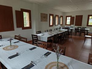 a dining room with tables and chairs with white tablecloths at Albergue Niu d'Estels in Albiol