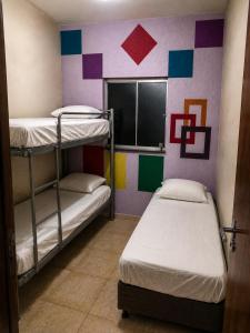 two bunk beds in a room with colorful walls at Jams Hostel - Pousada em Catalão in Catalão +6 photos