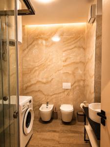 a bathroom with a toilet and a sink and a washing machine at Nova Apartaments Qerret ZL in Golem +43 photos