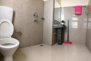 a bathroom with a toilet and a walk in shower at ཨོཾ Homestay in Lāmayūrū
