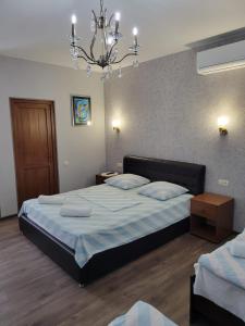 a bedroom with a large bed and a chandelier at Guesthouse Vashlovani in Lagodekhi