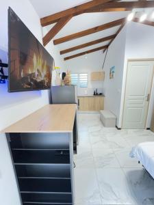 a kitchen with a desk and a tv on the wall at Studio Colibri vue mer in Quartier Morne Acajou