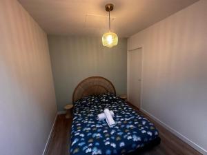a small bedroom with a bed with a white ribbon on it at Palma Verde - centre ville - wifi in Niort