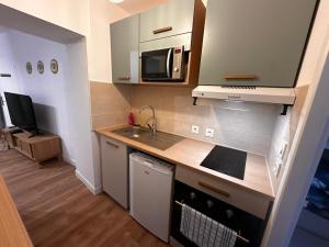 a small kitchen with a sink and a microwave at Palma Verde - centre ville - wifi in Niort