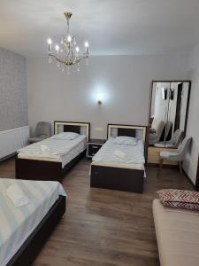 a room with two beds and a chandelier at Guesthouse Vashlovani in Lagodekhi