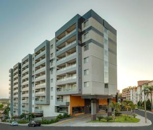 a large apartment building in front of a street at Apartamento Veredas Flat - Rio Quente in Rio Quente