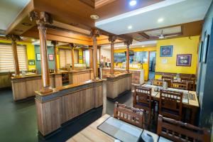 a restaurant with wooden tables and chairs and yellow walls at PLA Residency Tanjore in Thanjāvūr