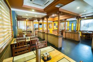 an empty restaurant with wooden tables and chairs at PLA Residency Tanjore in Thanjāvūr