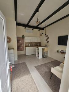 a living room with a table and a kitchen at Studio D lux Vida in Apatin