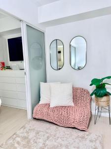 a room with a couch and two mirrors on the wall at SM Bicutan Quick Staycation PH in Manila +22 photos