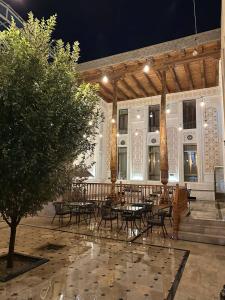 a patio with tables and chairs in front of a building at OROM PONORAMA VIEW old city in Bukhara
