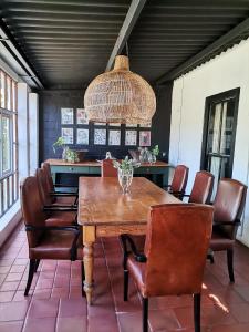 a dining room with a wooden table and leather chairs at De Oude Schuur in Stellenbosch