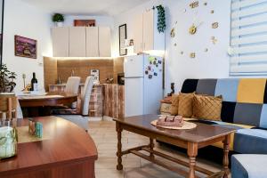 a kitchen and a living room with a couch and a table at Apartman Darija 3 in Gornji Orahovac