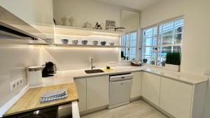 a white kitchen with a sink and a window at Dunas - Private Pool - 8 Guests - Albufeira in Albufeira